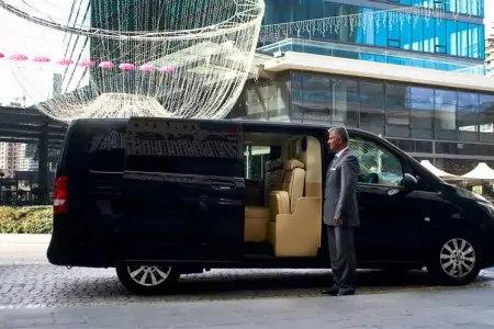 خدمة نقل VIP من عيادة Vita Estetic، حافلة مع سائق أمام مبنى حديث