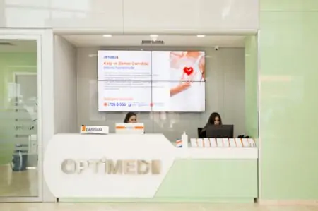 مكتب استقبال في مستشفى Private Optimed مع شاشة معلومات طبية حديثة