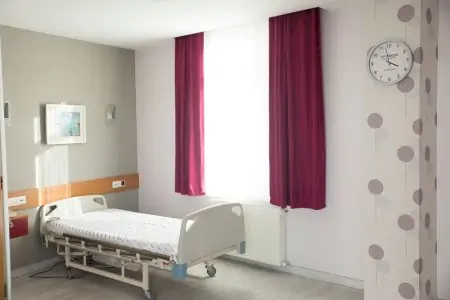 غرفة مريض في مستشفى برايفت أوبتيميد بسرير طبي وديكور حديث