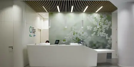 منطقة استقبال في GenesisCare Clinics بديكور عصري ولوحة زهور على الجدار