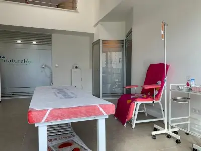 Sala de tratamiento en Natural Klinik con cama médica y soporte para suero