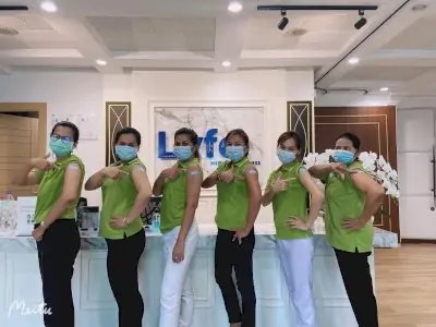 Personal de Lyfe Medical Wellness en recepción mostrando insignias de vacunación, clínica Phuket