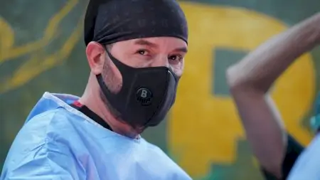 طبيب يرتدي قناع واقٍ وملابس طبية في عيادة Doctor B