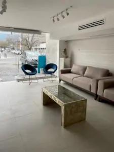 منطقة انتظار حديثة في Alivia Clinica Monterrey مع أريكة وكراسي
