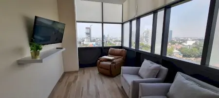 صالة انتظار المرضى في عيادة Alivia Clinica مكسيكو سيتي بإطلالة على المدينة ومقاعد مريحة