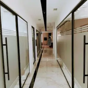 Pasillo moderno de clínica con puertas de vidrio en DM Klinik