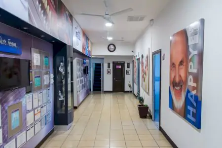 Pasillo en Dental Brush Clinic con certificados y fotos de pacientes, clínica dental moderna