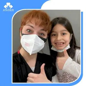 Dentista y paciente infantil sonríen en Atamer Oral and Dental Health Center