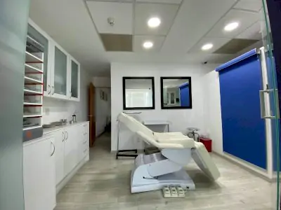 غرفة علاج في عيادة د. ماركو بولو لجراحة التجميل مع كرسي طبي حديث