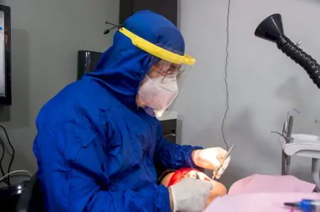 Dentista con equipo de protección realizando tratamiento en Laredo Smile Center