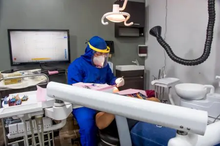 Sala de tratamiento dental en Laredo Smile Center con dentista con equipo de protección