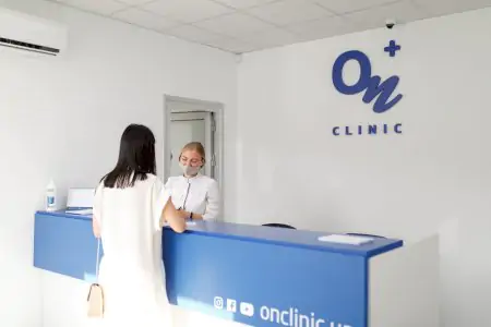 مكتب استقبال في عيادة ON Clinic خاركيف جاجارينا مع موظف يساعد مريضًا