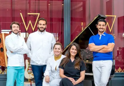 Equipo médico de W Clinics frente a la entrada de la clínica con piano