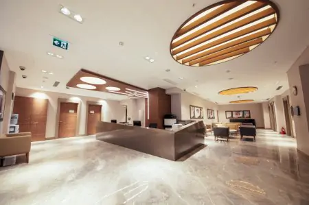 Área de recepción en IC ESTHETIC Clinic con asientos modernos y suelos de mármol