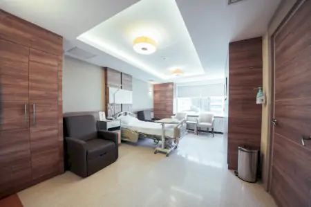 Habitación de paciente en IC ESTHETIC Clinic con mobiliario moderno y cama hospitalaria