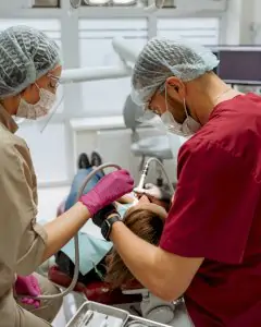 أطباء الأسنان يجرون إجراءً في غرفة علاج عيادة ميدينا للأسنان