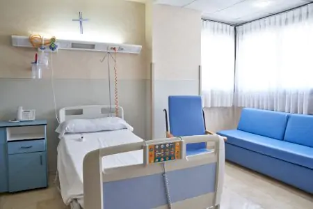 Habitación de paciente en Hospital HM Monteprincipe Madrid con cama moderna y asientos