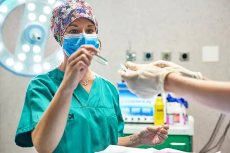 Personal médico preparando jeringa en quirófano de Hospital HM Puerta del Sur
