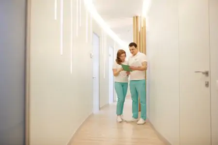 ممر مضاء في عيادة Avanto Dental مع طاقم يراجع ملفات المرضى