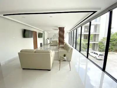 منطقة انتظار في Sani Dental Group Playa del Carmen بأرائك حديثة ونوافذ كبيرة
