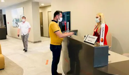 Mostrador de recepción en Dunyagoz Eye Hospital Izmir con personal y paciente con mascarillas