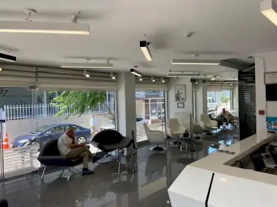 Sala de espera moderna en Dent Health Clinic con asientos cómodos y grandes ventanales