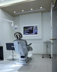 غرفة علاج حديثة في عيادة Hairplasis مع كرسي طبي ومعدات