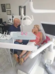 طبيب أسنان يستشير مريضًا في غرفة علاج حديثة في عيادة د. ليفنت أوروجو للأسنان إزمير