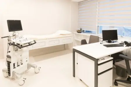غرفة استشارة مع جهاز الموجات فوق الصوتية في IC Clinic