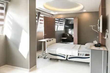 غرفة مرضى في IC Clinic بسرير حديث ومنطقة استراحة خاصة