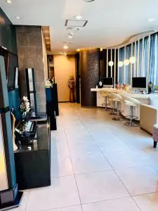 Recepción y sala de espera moderna en Evita Clinic con ordenadores y zona lounge