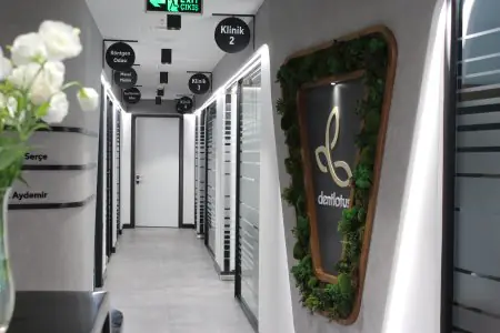 ممر حديث في عيادة Dentlotus مع لافتات مضيئة وأبواب زجاجية