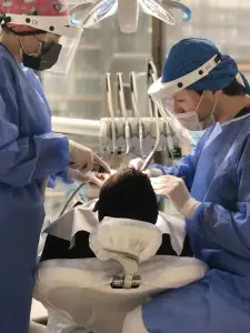 أطباء أسنان يجرون إجراءً في Dr Buyan Dental Clinic باستخدام معدات حديثة