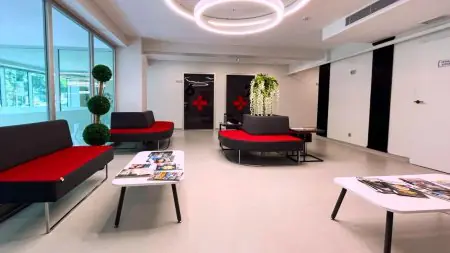 Sala de espera moderna en Turkey Hair Transplant Center con asientos rojos y revistas