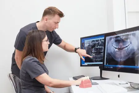 أطباء الأسنان يحللون صور الأشعة السينية للأسنان في عيادة Villa Nova Dental Clinic