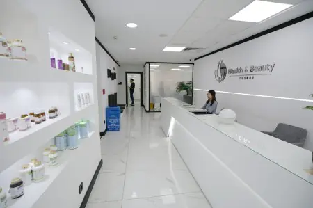 منطقة الاستقبال في عيادة Health & Beauty Turkey بتصميم داخلي أبيض عصري
