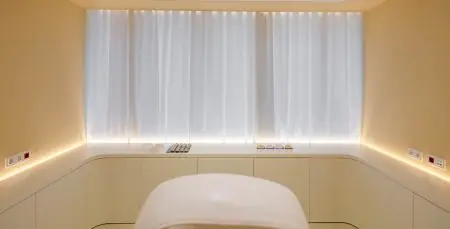 Sala de tratamiento minimalista en UPClinic con iluminación suave y decoración moderna