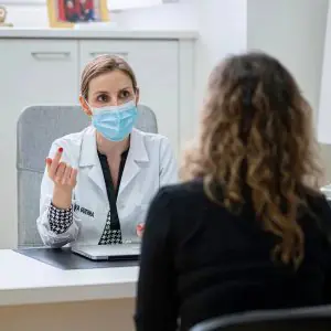 Doctora consultando a paciente en Ana Silva Guerra Clinic, consultorio moderno