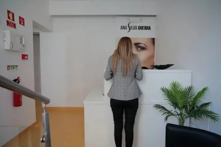 Mostrador de recepción en la clínica Ana Silva Guerra con decoración moderna y planta