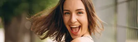 Mujer sonriente al aire libre cerca de JBM Plastic Surgery Costa Rica