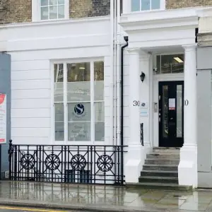 الواجهة الخارجية لـ The Kensington Clinic في لندن بواجهة بيضاء ومدخل بدرج