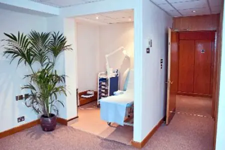 غرفة استشارة في Cosmetic Surgery Partners London بسرير فحص ومعدات طبية