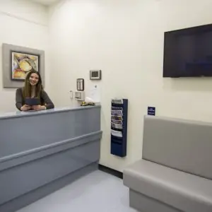 منطقة الاستقبال في The Kensington Clinic مع مقاعد حديثة ومكتب معلومات
