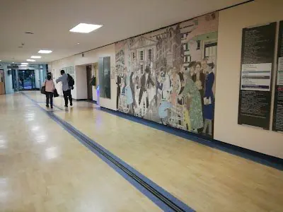 Pasillo en la clínica Liberate Cosmetic Surgery con mural y paneles informativos