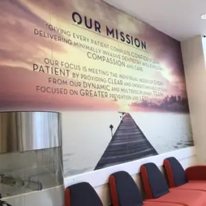 منطقة الانتظار في عيادة Ocean Dental مع لوحة جدارية لرسالة العيادة