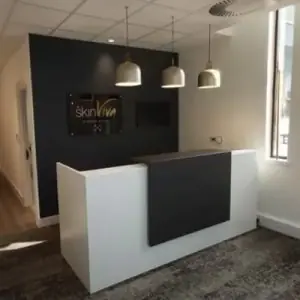 Mostrador de recepción en SkinViva Clinic con iluminación moderna y diseño minimalista
