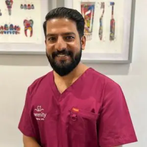 طبيب أسنان بالزي في عيادة Serenity Dental Spa مع مخططات أسنان بالخلفية