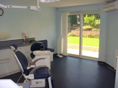 Sala de tratamiento dental en Scott Arms Dental Practice con sillón moderno y vista al jardín