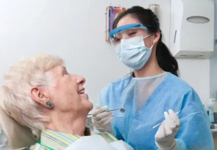 Dentista atendiendo a paciente mayor en Scott Arms Dental Practice, Reino Unido