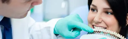 طبيب أسنان يطابق قشور الأسنان للمريض في عيادة The Dentist At Liberty Place